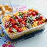Mexican Layer Dip with Tortilla Chips served in container
