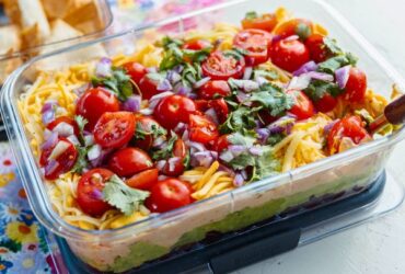 Mexican Layer Dip with Tortilla Chips served in container