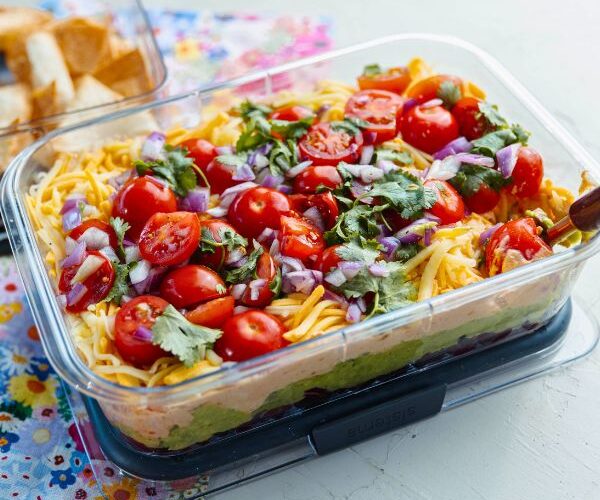 Mexican Layer Dip with Tortilla Chips served in container