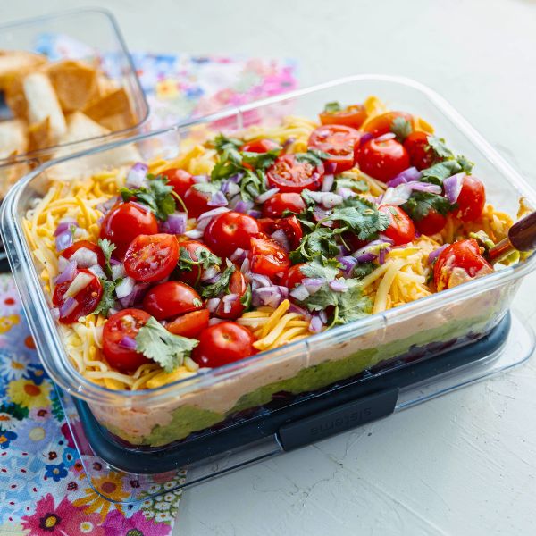 Mexican Layer Dip with Tortilla Chips Mexican Layer Dip with Tortilla Chips served in container