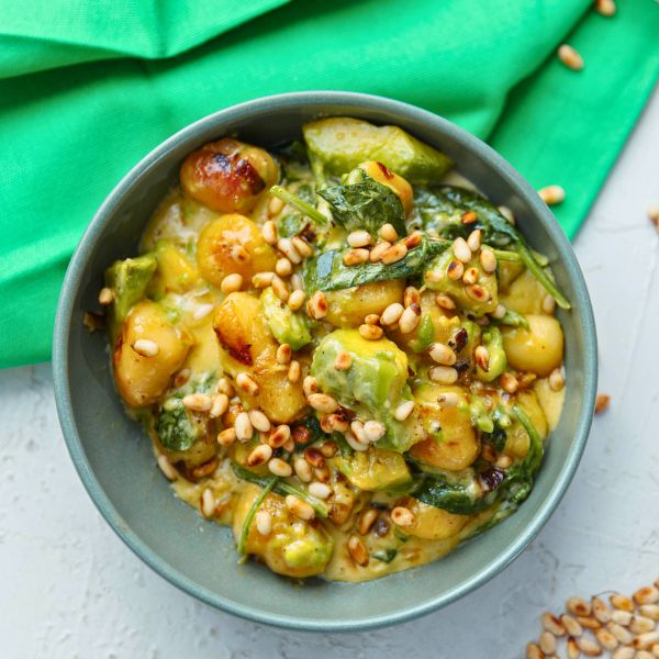 Avocado Gnocchi with Spinach and Pinenuts in bowl and served